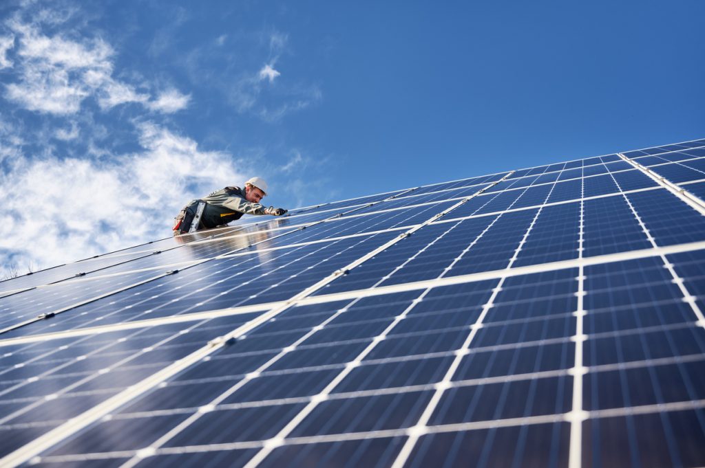 Ein Elektriker installiert ein Solarpanel