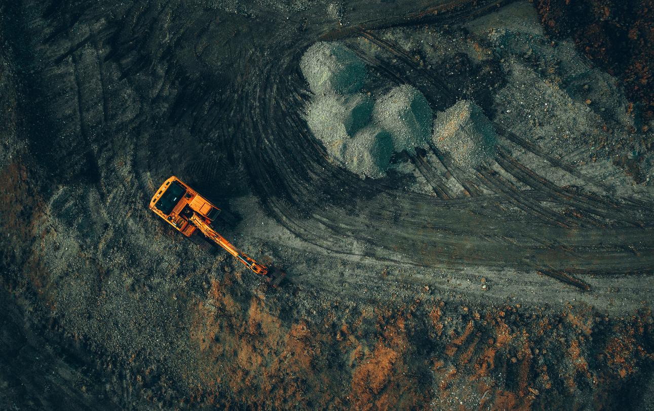 bright excavator at work on a dark background view from a drone bright excavator at work on a dark background view from a drone